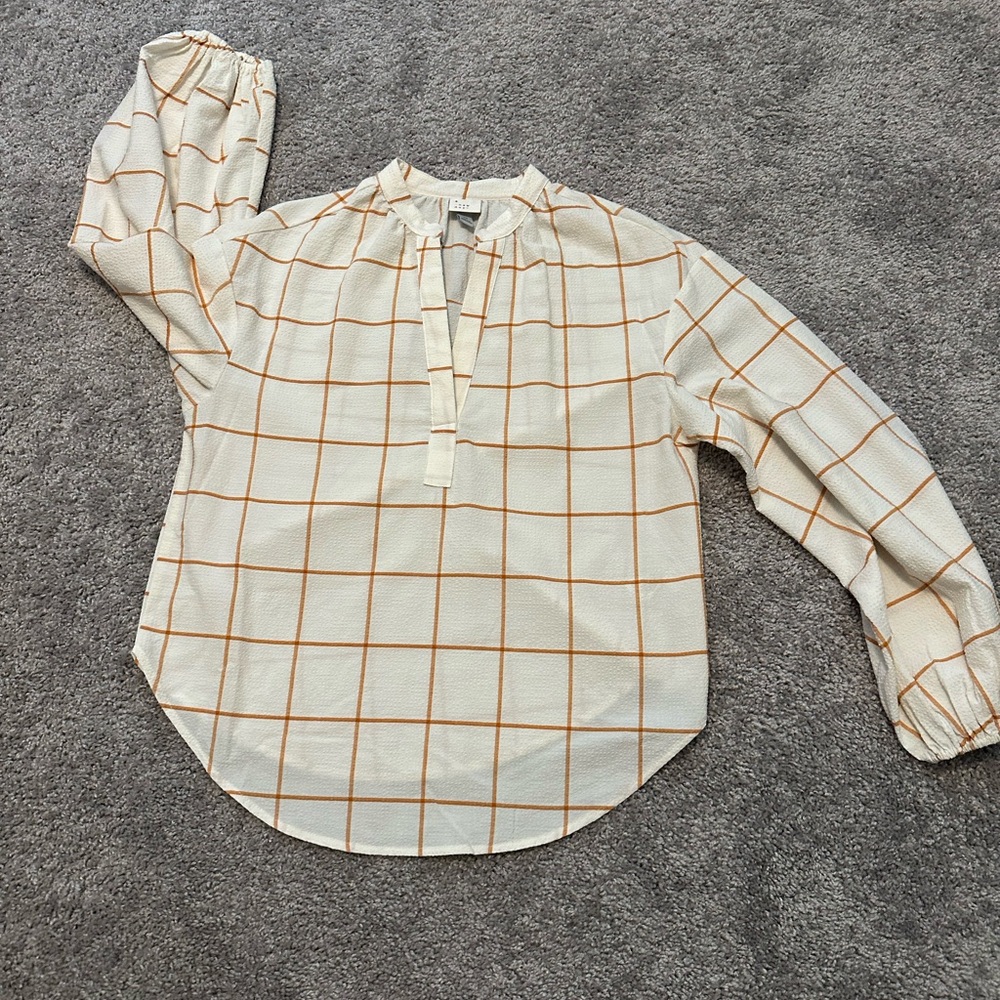a new day size xs. blouse. orange grid pattern on cream shirt.